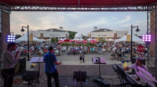 Musicians performing on stage with crowd in front