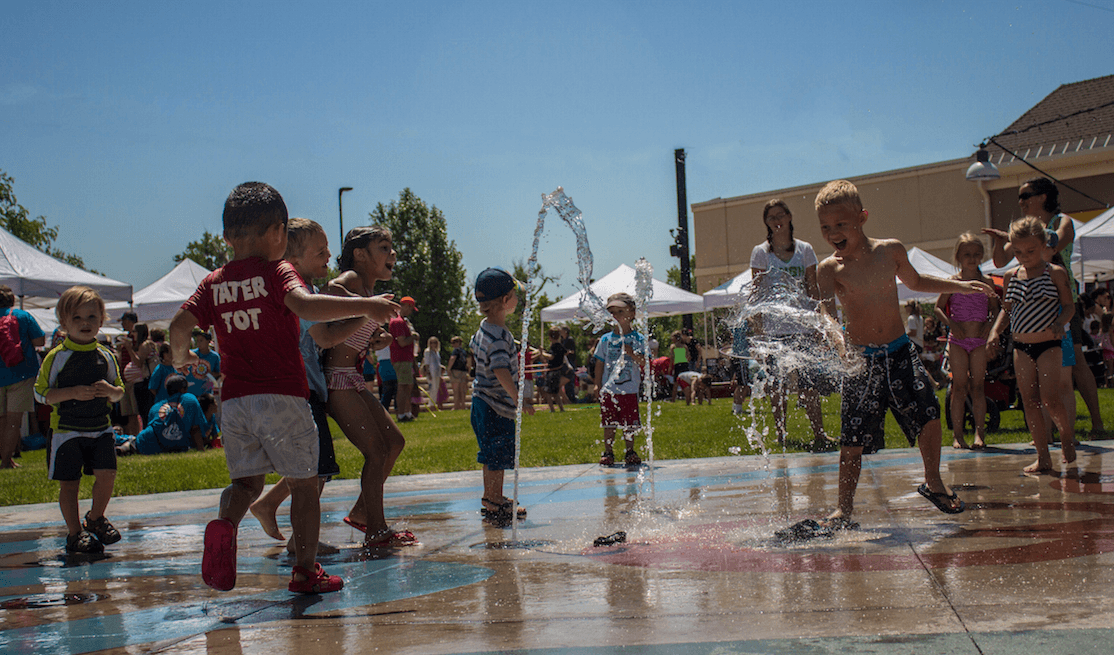 Children playing in water fountain