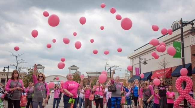 Group of people releasing pink balloons