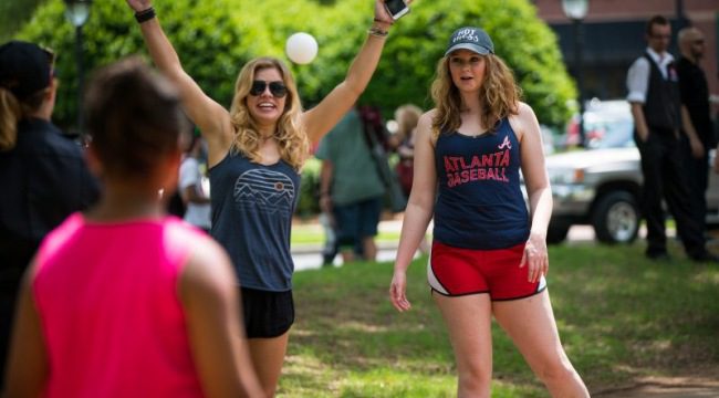 Two women wearing athletic clothing outdoors