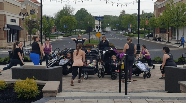 Group of moms gathered in open space with children and stretching
